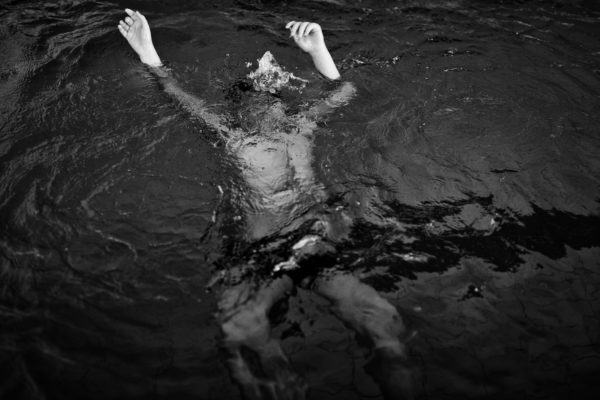black and white photo of a kid underwater 