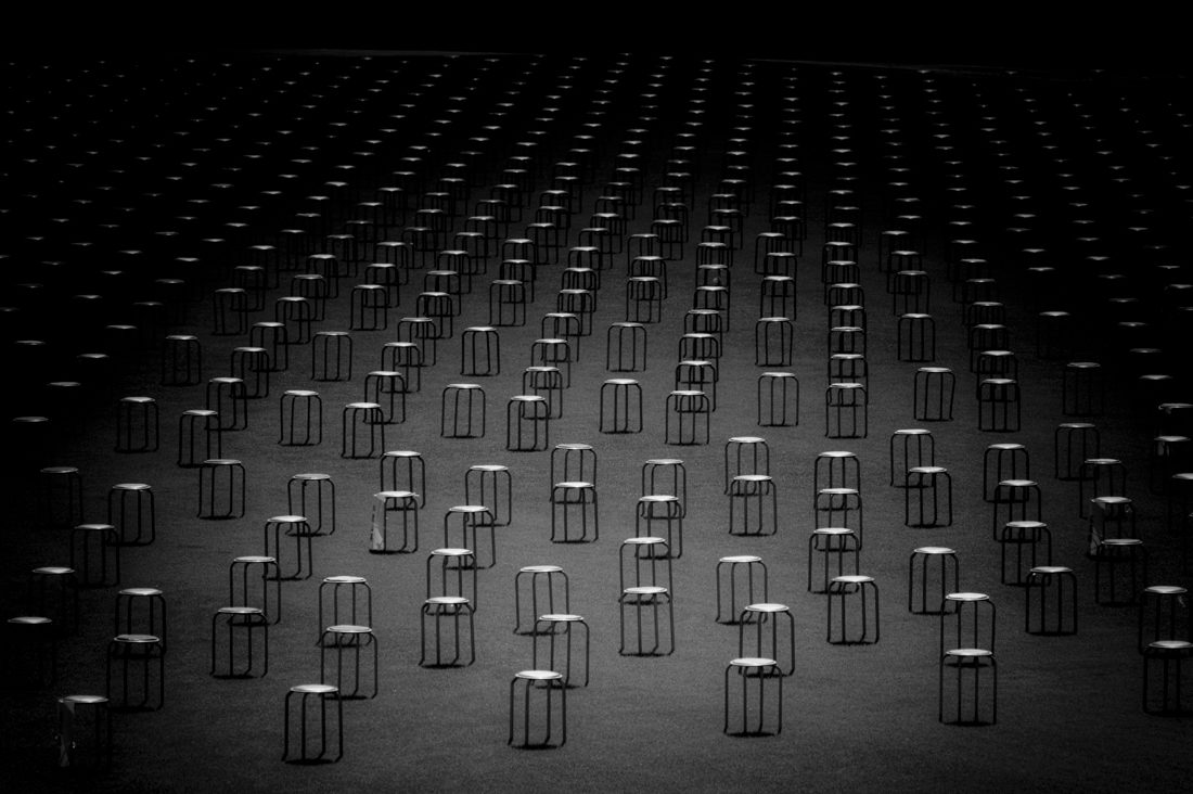 Rows of chairs sit in a dimly lit room
